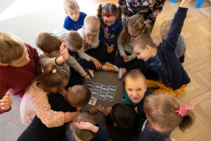 grupa dzieci gra w grę karcianą
