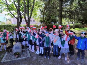 Zdjęcie przedstawia grupę przedszkolaków machającą biało-czerwonymi flagami.
