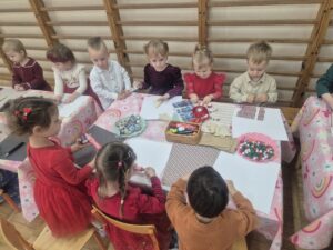 Zdjęcia przedstawia dzieci tworzące świąteczne ozdoby