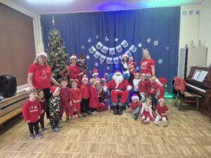 Zdjęcie przedstawia Mikołaja na fotelu wraz dziećmi